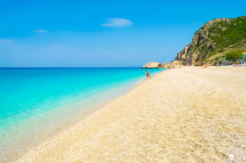 Plaja Kathisma din Lefkada, cu apă turcoaz și șezlonguri